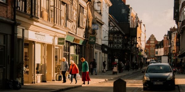 Vibrant street scene in Shrewsbury, England, featuring historic buildings and pedestrians in sunlight.