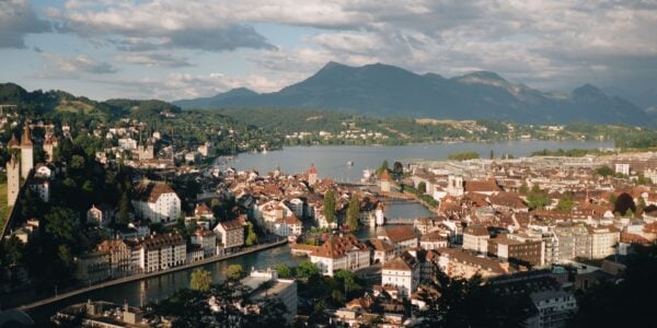 A picturesque aerial view of Lucerne, Switzerland featuring the cityscape, lake, and surrounding mountains.=