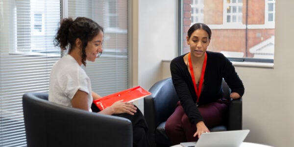 Young woman with a limb difference talking to a woman in office