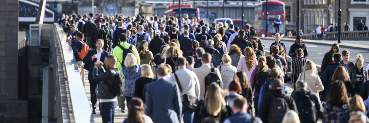 Large crowd of people commuting to work in London, England